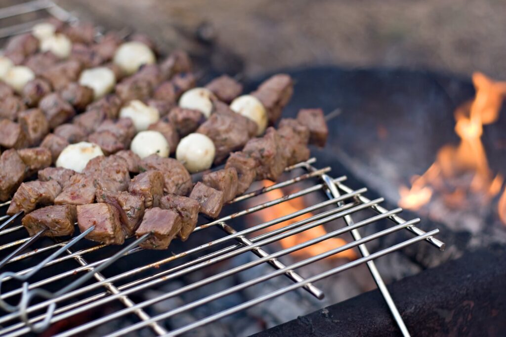 beef kabobs cooking on open fire