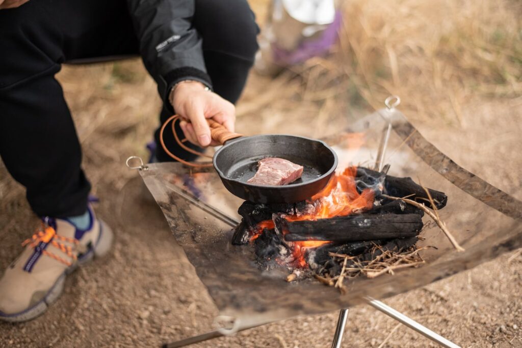 grilling steak over open fire